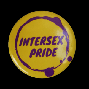 badge jaune, texte violet dans cercle violet " intersex pride"