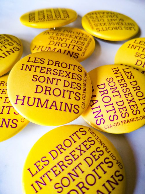 badges jaune ecriture violette "les droits intersexes sont des droits humains"